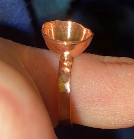 Bague en cuivre portée, anneau martelé surmonté d'une petite coupelle emboutie.